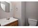Powder room featuring a wood vanity, round mirror, sink, and toilet at 8030 Cork Bend Ln, Indianapolis, IN 46239