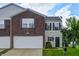 Home featuring a two-car garage, brick facade, and well-maintained lawn at 8030 Cork Bend Ln, Indianapolis, IN 46239