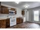 Modern kitchen showcasing white appliances, wood-look floors, and a convenient layout for meal preparation and dining at 8030 Cork Bend Ln, Indianapolis, IN 46239