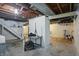 Unfinished basement with concrete floors, exposed duct work, and stairs at 808 N Layman Ave, Indianapolis, IN 46219
