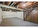 Unfinished basement with exposed ceiling, wood stairs, and white storage cabinets at 808 N Layman Ave, Indianapolis, IN 46219