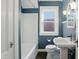 Cozy bathroom featuring blue walls, white tiling, a white pedestal sink, and a window for natural light at 808 N Layman Ave, Indianapolis, IN 46219