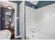 Bright bathroom featuring white tiling, a shower-tub combination, and an open doorway to the house at 808 N Layman Ave, Indianapolis, IN 46219