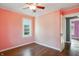 Bright bedroom with hardwood floors, pink walls, white trim, a large window, and an open doorway at 808 N Layman Ave, Indianapolis, IN 46219