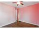 Comfortable bedroom featuring hardwood floors, pink walls, white trim, and overhead lighting at 808 N Layman Ave, Indianapolis, IN 46219
