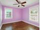 Bright bedroom with hardwood floors, ceiling fan, and natural light from the two windows at 808 N Layman Ave, Indianapolis, IN 46219