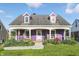 Charming purple two-story home featuring a welcoming front porch and beautifully landscaped front yard at 808 N Layman Ave, Indianapolis, IN 46219