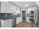 Bright kitchen featuring white cabinets, stainless steel appliances, and complementary backsplash at 808 N Layman Ave, Indianapolis, IN 46219