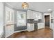 Bright kitchen featuring white cabinets, granite countertops, stainless steel dishwasher, and decorative lighting at 808 N Layman Ave, Indianapolis, IN 46219