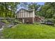 A well-maintained backyard with a grill, tiered garden and wooden steps leading to a grassy area at 8310 Fall Creek Rd, Indianapolis, IN 46256