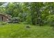 A grassy backyard with a fire pit and a hammock hanging between the trees at 8310 Fall Creek Rd, Indianapolis, IN 46256