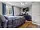 Cozy bedroom with ceiling fan, hardwood floors, and natural light at 8310 Fall Creek Rd, Indianapolis, IN 46256