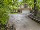 Beautiful exterior view of home with a driveway, a garage, and large surrounding trees at 8310 Fall Creek Rd, Indianapolis, IN 46256