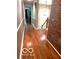 Hallway featuring hardwood floors, a brick wall, and a modern chandelier at 8310 Fall Creek Rd, Indianapolis, IN 46256