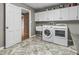 Functional laundry room with a washer, dryer, storage cabinets, and neutral-toned flooring at 8310 Fall Creek Rd, Indianapolis, IN 46256
