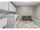 Functional laundry room with washer, dryer, laundry sink, cabinets, and folding table at 8310 Fall Creek Rd, Indianapolis, IN 46256