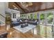 Expansive living room with vaulted wood ceiling, large windows, hardwood floors, and a leather sectional at 8310 Fall Creek Rd, Indianapolis, IN 46256