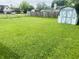 Expansive backyard with lush lawn, a storage shed, and a wooden fence, providing ample outdoor space at 8318 Rob Ln, Indianapolis, IN 46237