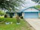 Charming single Gathering home featuring stone accents, a blue garage door and lush landscaping at 8318 Rob Ln, Indianapolis, IN 46237