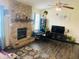 Comfortable living room featuring a stone fireplace, hardwood floors and a ceiling fan at 8318 Rob Ln, Indianapolis, IN 46237