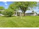 This backyard features a stone exterior, shade tree, and covered porch at 861 Westbrook Dr, Mooresville, IN 46158