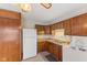 Practical kitchen design with classic wood cabinetry, white refrigerator, and laundry appliances at 861 Westbrook Dr, Mooresville, IN 46158