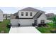Charming two-story home featuring a three-car garage, well-manicured lawn, and stylish architectural details at 8690 Lester Pl, Pendleton, IN 46064