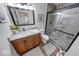 Bathroom featuring a wooden vanity, sink, and a glass shower with mosaic stone details and black trim at 8720 Yardley Ct # 207, Indianapolis, IN 46268