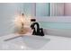 Close up on bathroom sink with bronze faucet and vanity lamp at 8720 Yardley Ct # 207, Indianapolis, IN 46268
