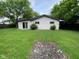 Spacious backyard featuring sliding door, grass lawn, and mature shade trees at 9045 Stardust Dr, Indianapolis, IN 46229
