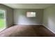 Vacant carpeted living room features a sliding glass door and small window at 9045 Stardust Dr, Indianapolis, IN 46229