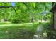 Expansive backyard featuring lush green grass, mature trees, and a stone pathway at 9101 Ditch Rd, Indianapolis, IN 46260