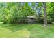 Serene backyard with lush greenery and a brick outbuilding provides privacy at 9101 Ditch Rd, Indianapolis, IN 46260