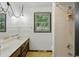 Bright bathroom with a double vanity, shower, and window with blinds at 9101 Ditch Rd, Indianapolis, IN 46260