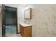 Bathroom showcases a vanity with mirror and floral wallpaper, needing renovation at 9101 Ditch Rd, Indianapolis, IN 46260
