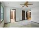 Bright bedroom with multiple doorways, a ceiling fan, and window views at 9101 Ditch Rd, Indianapolis, IN 46260