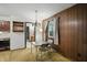Dining area features wood paneling, a window, and a chandelier, offering a cozy space to eat at 9101 Ditch Rd, Indianapolis, IN 46260