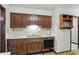Galley kitchen boasts wood cabinetry, a stainless steel sink, and vintage floral wallpaper at 9101 Ditch Rd, Indianapolis, IN 46260
