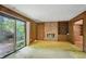A living room featuring a brick fireplace, built-in shelves, and sliding glass doors to the backyard at 9101 Ditch Rd, Indianapolis, IN 46260