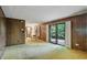 The spacious living room features wood paneling, a sliding glass door, and connects to the dining area at 9101 Ditch Rd, Indianapolis, IN 46260