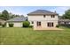 Backyard featuring lush green grass, a brick patio, and an attached two-story home with a gray roof at 9205 Selkirk Ct, Indianapolis, IN 46260