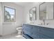 Elegant bathroom features a double sink vanity with a blue base, white countertops, and decorative mirrors at 9205 Selkirk Ct, Indianapolis, IN 46260