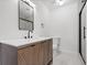 Bathroom featuring a wooden vanity with marble countertop, modern fixtures, and glass-enclosed shower at 9205 Selkirk Ct, Indianapolis, IN 46260