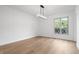 Empty bedroom with hardwood floors, neutral paint, decorative window, and modern light fixture at 9205 Selkirk Ct, Indianapolis, IN 46260