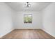 Bright, minimalist bedroom featuring hardwood floors, a diamond-paned window, and contemporary light fixture at 9205 Selkirk Ct, Indianapolis, IN 46260