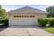 Two car garage in a home with a paved driveway surrounded by greenery at 9205 Selkirk Ct, Indianapolis, IN 46260