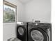 Laundry room with full sized front load washer and dryer next to a window at 9205 Selkirk Ct, Indianapolis, IN 46260