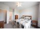 A clean bedroom with neutral colors, ceiling fan, and an attached bathroom through doorway at 9671 Holborn Ave, McCordsville, IN 46055