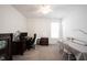 Neutral bedroom/office with carpet, ceiling fan, dark wood desk, and white trim, offering versatility and comfort at 9671 Holborn Ave, McCordsville, IN 46055