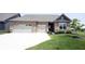 Charming brick home boasts a well-manicured lawn, two-car garage, and inviting front entrance at 9671 Holborn Ave, McCordsville, IN 46055
